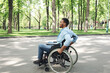 © Prostock-studio - Side view of young black guy in wheelchair spending time at city park, full length. Millennial African American man with physical disability using mobility aid, having walk outdoors, copy space