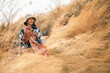 © chokniti - Woman traveler wearing colorful patterned sweater and hat standing in golden grass field under warm sunlight enjoying nature, outdoor adventure, and peaceful autumn atmosphere at countryside