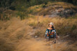 © chokniti - Woman traveler wearing colorful patterned sweater and hat standing in golden grass field under warm sunlight enjoying nature, outdoor adventure, and peaceful autumn atmosphere at countryside
