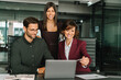 © Stock 4 You - Smiling mature Latin hispanic business woman and European young team working using laptop computer in office. Diverse colleagues coworkers group of professional business people discussing project