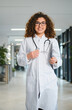 © Serhii - Smiling female doctor working in modern clinic hallway