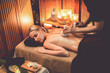 © InfiniteFlow - Hot herbal ball spa massage body treatment, masseur gently compresses herb bag on woman body. Tranquil and serenity of aromatherapy recreation in warm lighting of candles at spa salon. Quiescent