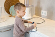 © New Africa - Child safety at home. Little boy plugging electric juicer into power outlet in kitchen