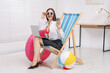 © New Africa - Woman with laptop and smartphone on deckchair in office