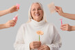 © Pixel-Shot - Mature woman and hands with feminine hygiene products on light background. Menopause concept