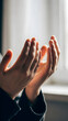 © Stargazerstd - Hands reaching upward prayer gesture isolated against a soft blurred background light and shadow