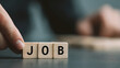 © Kanomaoi - A hand placing a wooden block to complete the word job daily