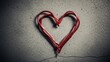 © SAPON - Vibrant red cable forming a heart shape on rough concrete