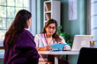 © StockImageFactory - Experienced Indian woman doctor consulting young beautiful patient with case file