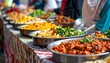 © aref - Assorted international cuisine on display at a bustling street food market stall with various dishes and vibrant colors