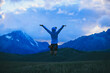 © lzf - Woman runner jumping at  the beautiful grassland mountain top