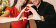 © Prostock-studio - Romantic Relationship Concept. Closeup portrait of happy smiling couple making heart shape with hands, having dinner together in the evening, selective focus on fingers. Love, Connection And Bonding