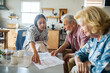 © Marko Geber - Financial advisor meeting with senior couple at home kitchen table