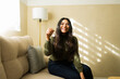 © AntonioDiaz - Happy woman holding new house keys, smiling at camera after buying first apartment or renting home
