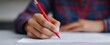 © ckybe - The teacher grades student assignments using a red pen.