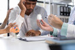 © Wasan - Doctor showing medicine bottle to sad patient during medical consultation, explaining prescription and treatment in hospital clinic.
