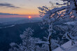 © Travel 'n' Lifestyle - View of snow-laden trees frame a radiant sunset over the mountainous landscape, painting the sky with hues of orange and pink, Nizke Tatry, Banska Bystrica Region, Slovakia.