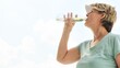 © Rawpixel.com - Woman drinking water outdoors, wearing a cap and t-shirt. Refreshing water, hydration, and outdoor activity. Clear sky background, healthy lifestyle. Woman drinking water, hydrated, sky background.