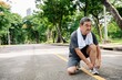 © Rawpixel.com - Elderly Asian man tying shoelaces on a park path, preparing for exercise. The Asian man is focused on fitness in the park. Healthy elderly Asian man tying running shoes in the park.