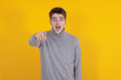 © carballo - isolated young man pointing with a surprised expression