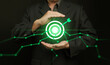 © OleCNX - Data-driven target and growth concept with businessman holding glowing bullseye, green analytics graphs hitting the center. Business precision, performance, intelligence, focus, objective, strategy.
