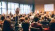 © Oleh - Audience members raising hands during a conference or seminar, actively participating in a discussion or question and answer session with presenters on a stage