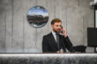 © Serhii - Hotel concierge talking on telephone at reception desk