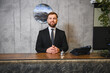 © Serhii - Male hotel receptionist standing at service desk