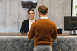 © Serhii - Hotel receptionist welcoming guest at front desk check in