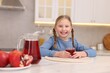 © New Africa - Little girl with fresh pomegranate juice at table indoors