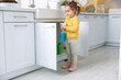 © New Africa - Child safety at home. Little girl with bottle of cleaning product in kitchen