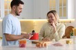 © New Africa - Couple cooking together at white marble table in kitchen
