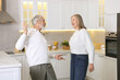 © New Africa - Happy senior couple dancing together in kitchen