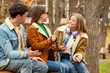 © Pixel-Shot - Blind young woman with her friends talking on bench outdoors