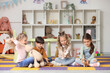 © Pixel-Shot - Group of little children playing with toys in kindergarten