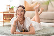 © Pixel-Shot - Young happy female hippie lying on floor at home