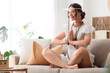 © Pixel-Shot - Young happy female hippie meditating on sofa at home