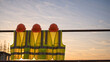 © Vyatcheslav - Construction safety helmets and high visibility vests hanging on scaffolding. Orange hard hats and yellow protective gear at sunset. Industrial site background with copy space