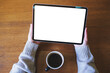 © Farknot Architect - Top view mockup image of a woman holding digital tablet with blank white desktop screen in cafe