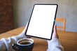© Farknot Architect - Mockup image of a woman holding digital tablet with blank white desktop screen in cafe