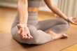 © Leny Studio - Calm woman meditation in lotus pose on yoga mat with neutral activewear and soft natural light
