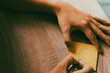 © sapol - Close up of hand drawing a heart symbol on yellow sticky note with pen on wooden table, concept of creating love, romance, and heartfelt message.