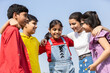 © GAJENDRRA BHATI  - Happy group of indian kids friends embracing and sharing a candid conversation together in summer park, concept of teamwork and friendship. Children having fun talking and discussing outdoor.