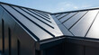 © Artiroz - Sleek metallic standing seam roof of a contemporary building, showcasing modern architecture with sharp lines and geometric design under a clear sky