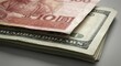© 5 Grace Media - Stack of American dollar bills with Chinese yuan banknote on top, currency exchange concept.