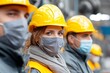 © Sasha - Workers in safety gear stand together in an industrial setting during a team meeting in the morning