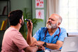 © StockImageFactory - Senior Indian physician uses medical torch to examine young male patient in modern clinic