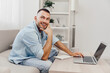 © SHOTPRIME STUDIO - Smiling man working from home, cozy interior, casual attire, modern design, positive vibes, focused on laptop, creativity in action.