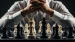 © Ambar - Business strategy and competition concept: Close-up of a professional person planning their next move on a chessboard, hands clasped, symbolizing leadership, decisive action, and corporate rivalry aga