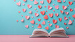 © Chopang.studio - Valentine paper heart shapes float above open book on pastel blue and pink background creating romantic and creative valentine atmosphere perfect for love and reading themes